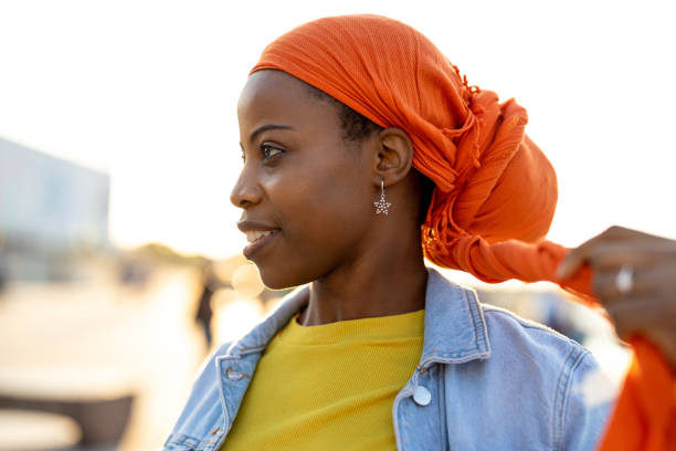 istock Beautiful young woman putting on headscarf 1324717258