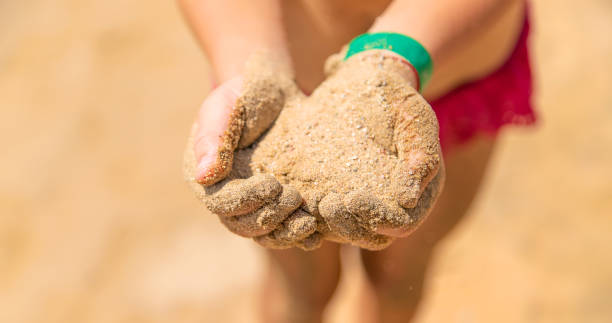istock Sand in the hands of a child. Selective focus. 1324717518