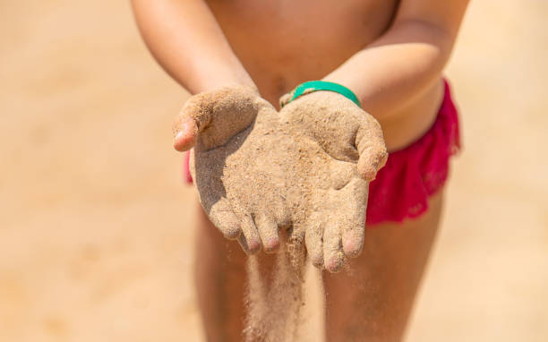 istock Sand in the hands of a child. Selective focus. 1324717529