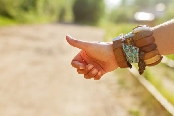 istock female hand in ethnic bracelets votes on the road on summer day 1324717622