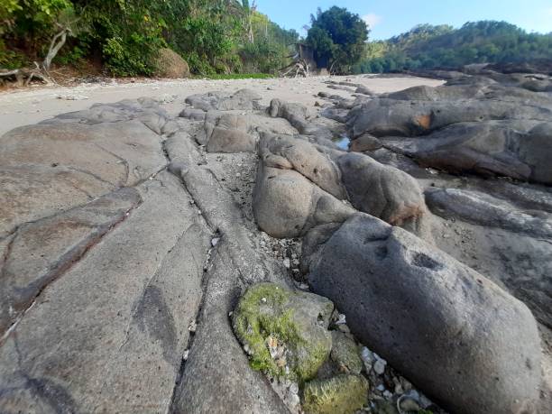istock Low angle view from grey ball shaped rock stones at a rocky sand beach 1324718740