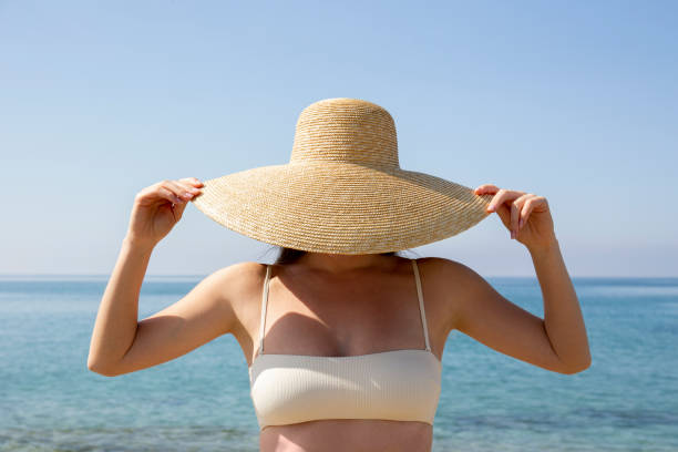 istock Woman in straw hat at the beach 1324718998