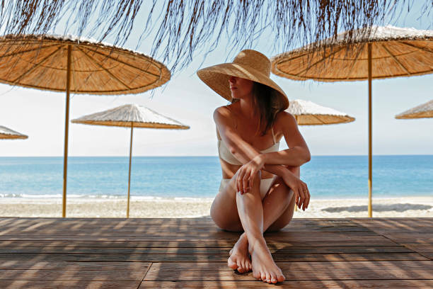 istock Woman in straw hat at the beach 1324719733