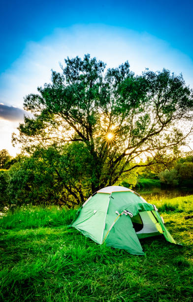 istock green tourist tent by the river at sunset 1324720279