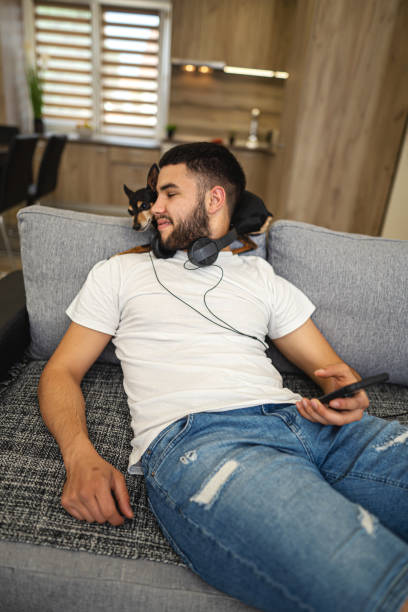 istock Young man using phone while hanging out with his dog pet 1324722094