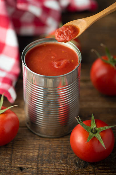 istock Open tin of tomatoes sauce with whole fresh tomatoes on a rustic wooden table 1324722112