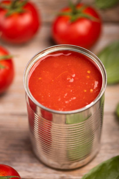 istock Open tin of tomatoes sauce with whole fresh tomatoes on a rustic wooden table 1324722152