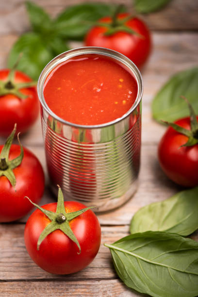istock Open tin of tomatoes sauce with whole fresh tomatoes on a rustic wooden table 1324722886