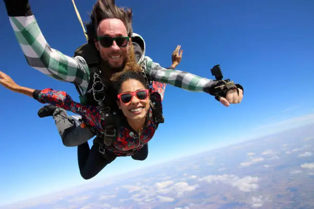 Photo of Tandem parachute jump. Beautiful Brazilian woman.