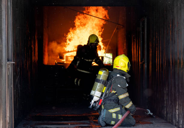 istock Two firefighters of fireman try to extinguish the fire in container during the practice of their job 1324724946
