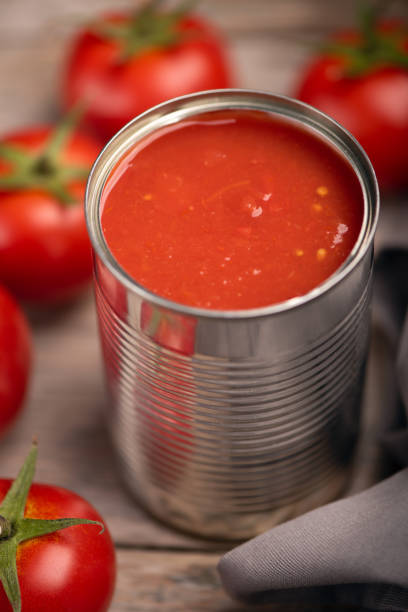 istock Open tin of tomatoes sauce with whole fresh tomatoes on a rustic wooden table 1324725031
