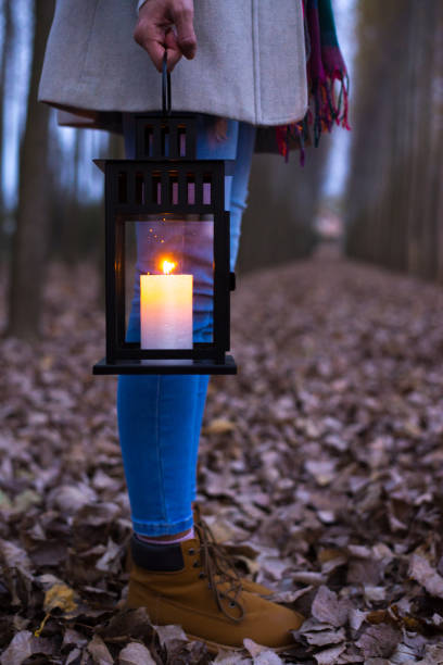 istock Woman with lantern in the woods at night 1324726088