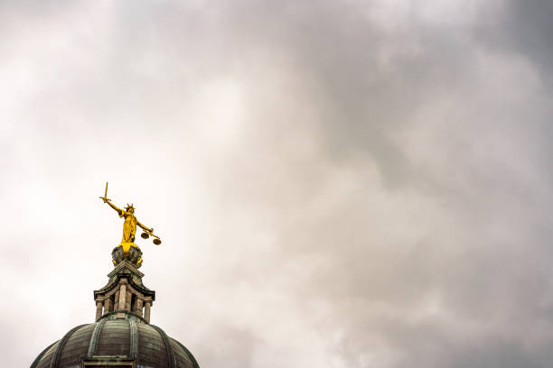 Lady Justice facing a stormy sky Storm clouds gathering above and around the statue of Lady Justice on the top of the main dome of the Royal Courts of Justice, known as Old Bailey after the street name in the City of London. royal courts of justice stock pictures, royalty-free photos & images