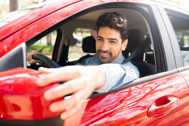 istock Man moving rear view wing mirror in car. 1324730677