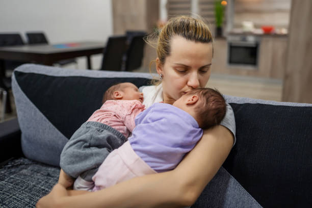 istock Mother holding her twin babies. 1324730684