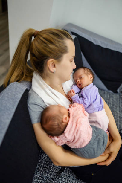 istock Mother holding her twin babies. 1324730696