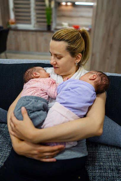 istock Mother holding her twin babies. 1324730739