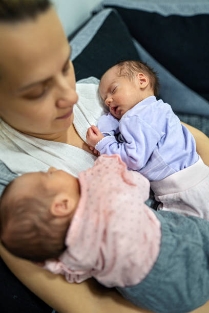 istock Mother holding her twin babies. 1324730742