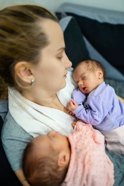 istock Mother holding her twin babies. 1324730787