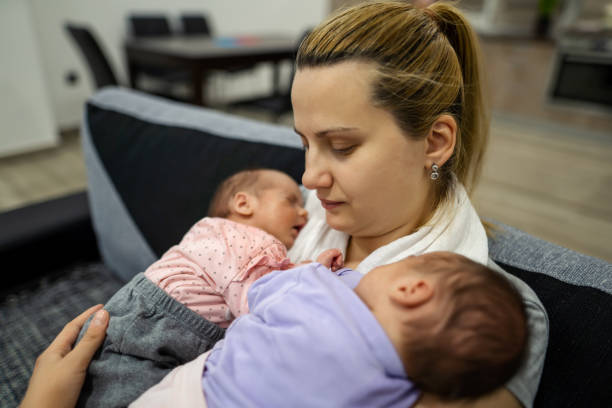 istock Mother holding her twin babies. 1324731346