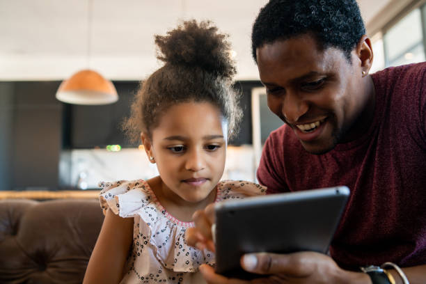 istock Father and daughter using digital tablet at home. 1324731408