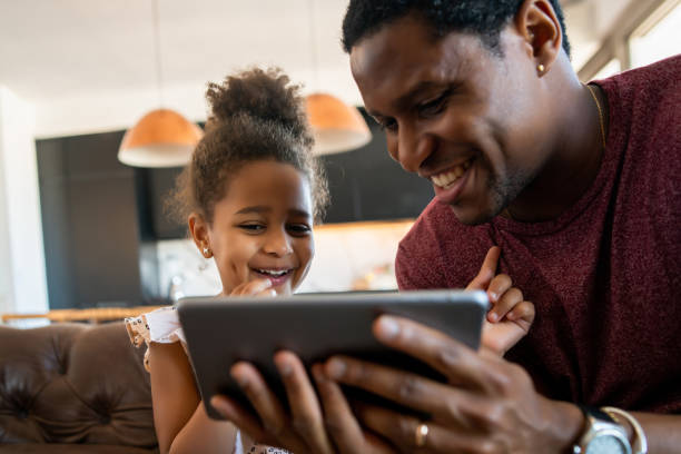 istock Father and daughter using digital tablet at home. 1324731418