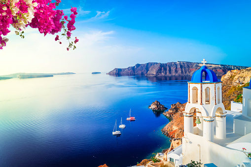 white church belfry and volcano caldera with sea landscape, beautiful details of Santorini island, Greece with flowers