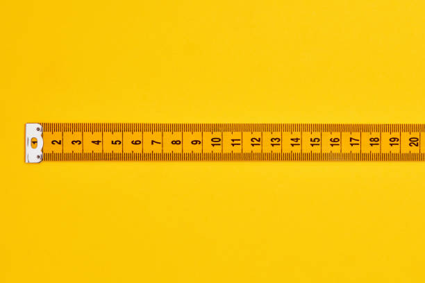 istock Straight tape measure on yellow background 1324733233