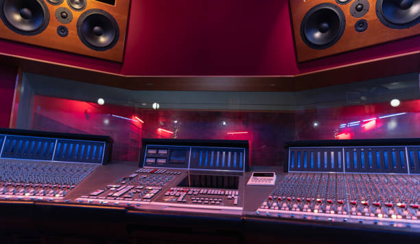 istock Mixing Audio Control Panel, High Power Speakers And View Through Soundproof Window On Musicians 1324733489