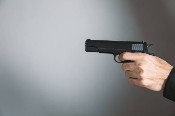 istock man holding a black pistol in his hand 1324734481
