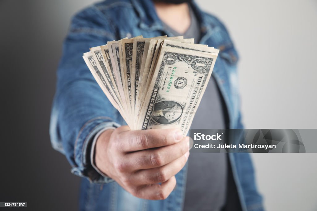 man holds money and shows man holds wads of money and shows Adult Stock Photo
