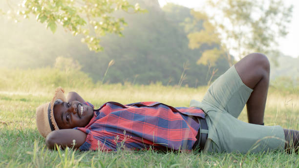 istock African man relaxing on green grass outdoors in summer with happily on vacation 1324734672