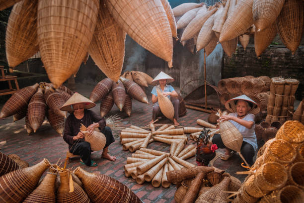Vietnamese fishermen are doing basketry for fishing equipment at morning in Thu Sy Village, Vietnam. Vietnamese fishermen are doing basketry for fishing equipment at morning in Thu Sy Village, Vietnam. basket weaving stock pictures, royalty-free photos & images