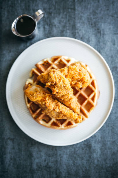 gourmet huhn und waffeln vergoldet restaurant stil mit seite von sirup in silber krug - waffle syrup pouring breakfast stock-fotos und bilder