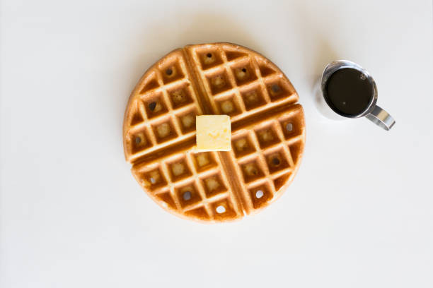 Gourmet Chicken and Waffles Plated Restaurant Style with Side of Syrup in Silver Pitcher Above View of Crispy Fried Chicken Over Belgian Waffles with Butter and Maple Syrup comfort food stock pictures, royalty-free photos & images