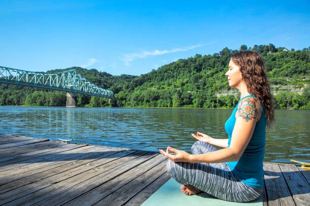 A woman practicing yoga on a beautiful summer morning by the Sewickley Bridge in western Pennsylvania.