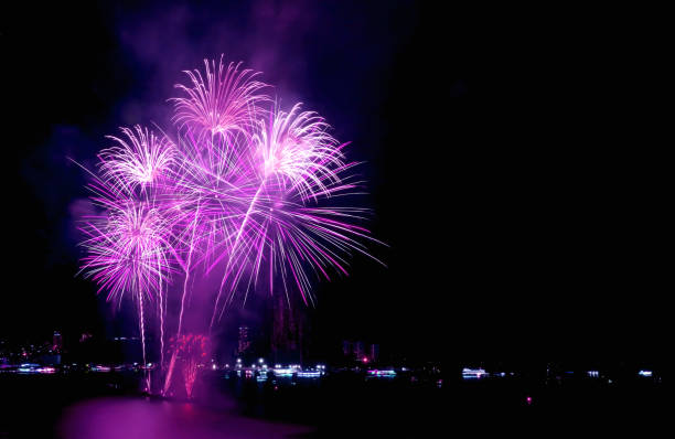 istock Stunning purple pink fireworks exploding into the night sky over the harbor 1324742127