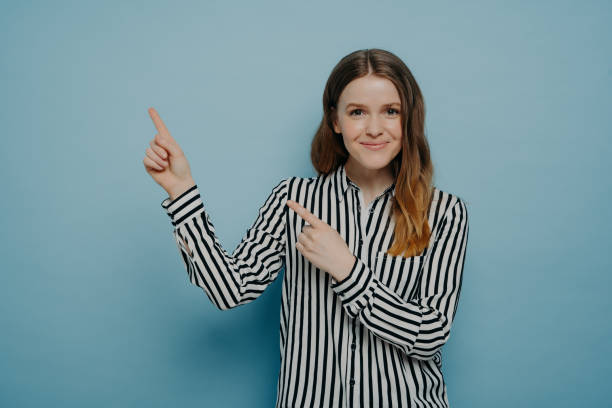 istock Studio shot of happy female pointing up at copy space 1324745328