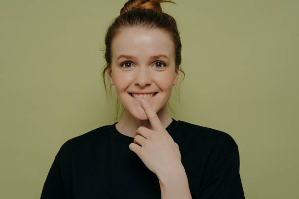 istock Cute thoughtful teenage girl biting lower lip while posing in studio 1324746469