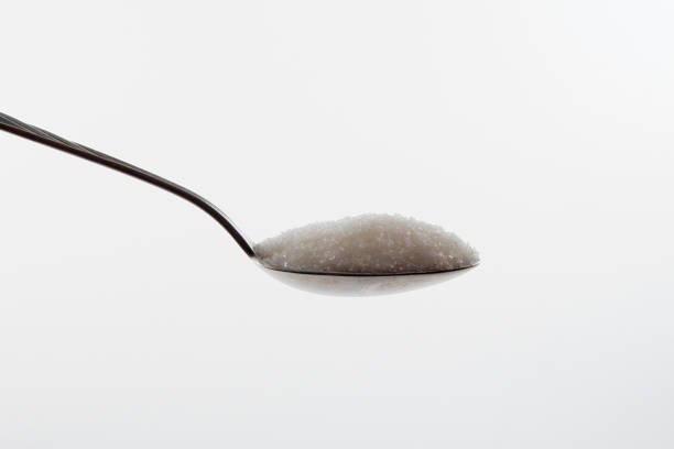 istock sugar in a spoon, isolated on a white background 1324746743