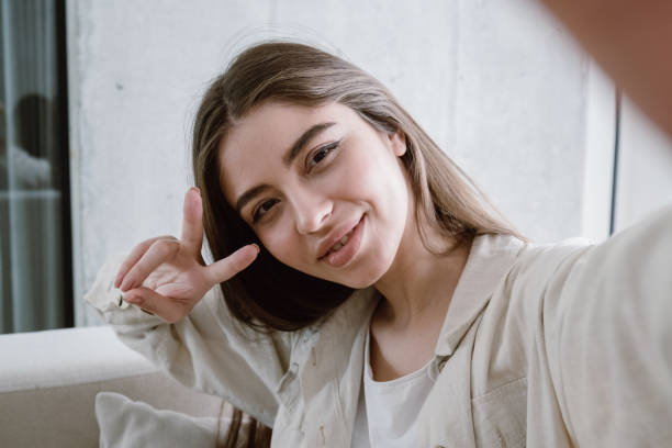istock Young woman making selfie, showing victory sign 1324748096
