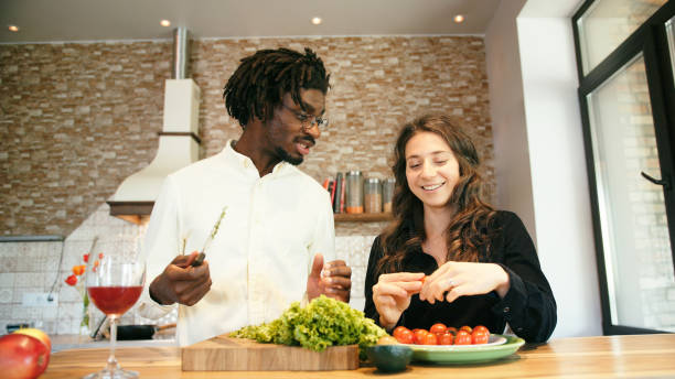 istock Young couple cook together and drink wine in kitchen 1324749716