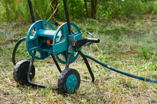 istock Green babin with watering hose, compact garden tool 1324749772