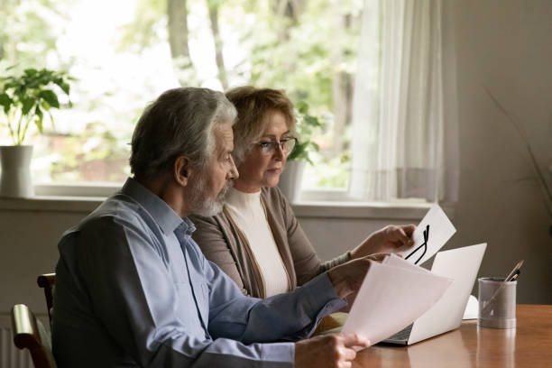 istock Older couple work with paperwork paying bills online 1324756550