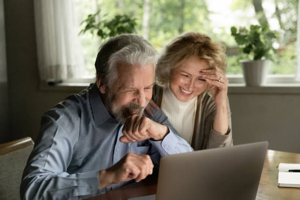 istock Smiling mature couple talk on webcam call on laptop 1324756554