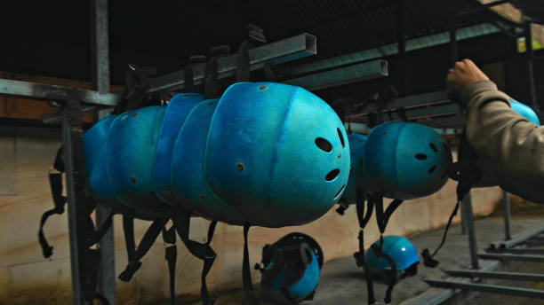 Colored protective helmets for the head to practice rafting hanging on the wall