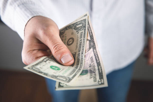 istock man keeps money and gives to another 1324758871