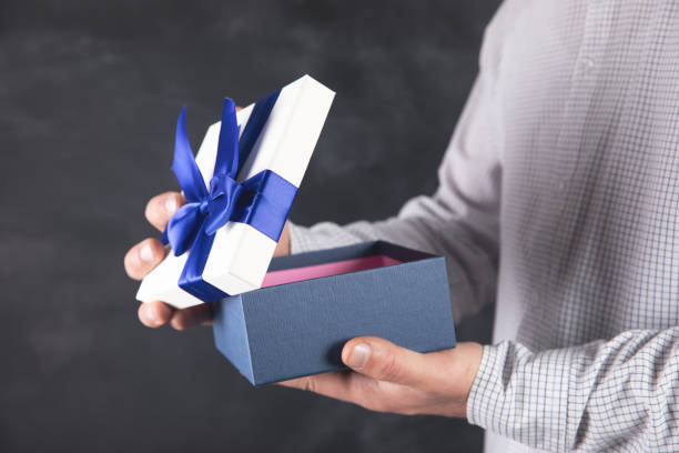 istock Young man opens a fascinating gift box 1324758896