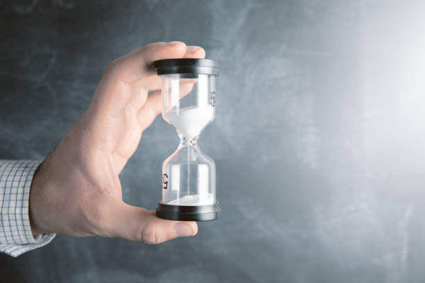 istock man holding an hourglass in his hand 1324758951