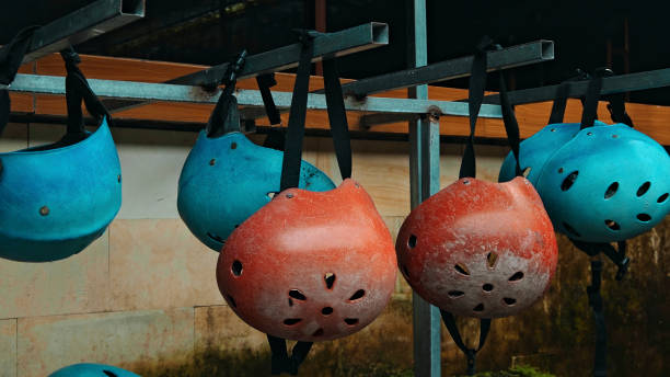Colored protective helmets for the head to practice rafting hanging on the wall